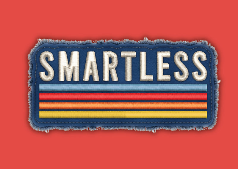 Close up of patch with the word 'SMARTLESS' in bold, embroidered letters, accompanied by colorful horizontal stripes on a blue background, with a textured edge, set against an orange background.