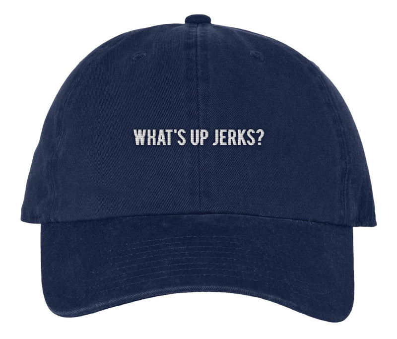 A navy blue baseball cap with white embroidered text on the front that reads, 'WHAT'S UP JERKS?' in uppercase letters. The hat has a curved brim and a structured six-panel design.