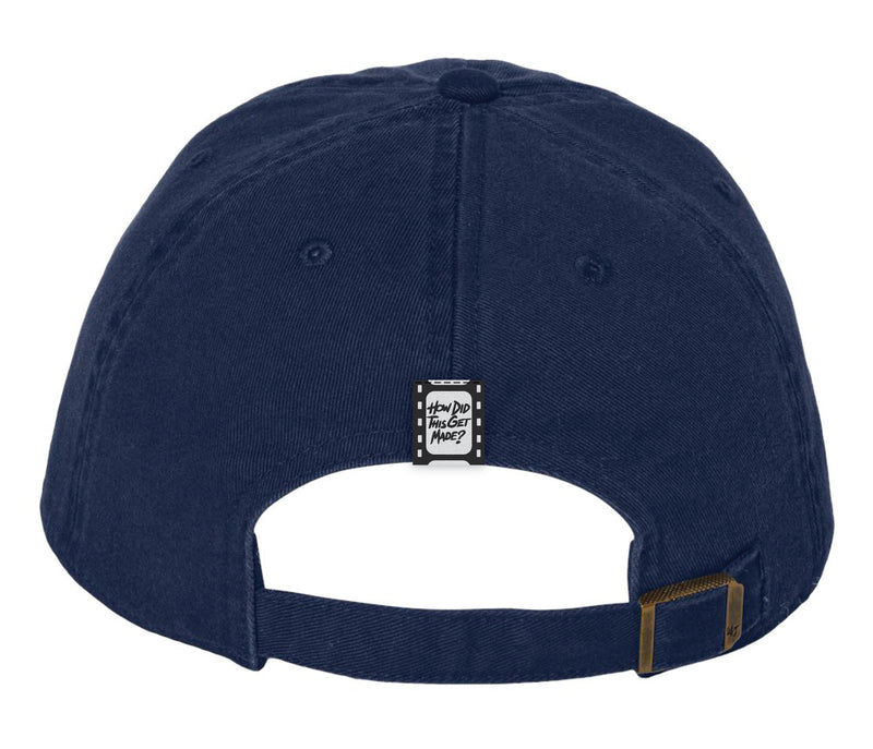 The same navy blue baseball cap shown from the back. It features an adjustable strap with a brass buckle. A small black tag with white text that reads 'HOW DID THIS GET MADE?' is sewn onto the back of the cap, resembling a film strip design.