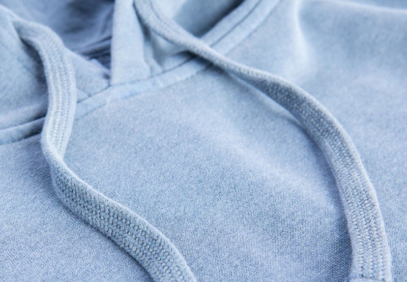 Close-up of a light blue hoodie with drawstrings.