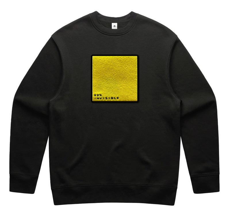 Black sweatshirt featuring a central yellow square with the text '99% INVISIBLE' at the bottom.