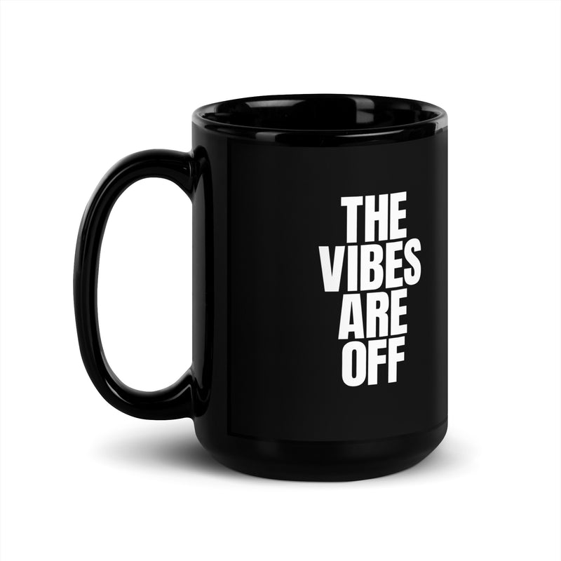 A larger 15 ounce black glossy coffee mug featuring 'THE VIBES ARE OFF' text in white, with the handle on the left side.