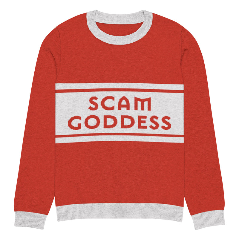 A red sweater with gray cuffs and collars featuring the text 'SCAM GODDESS' against a grey stripe on the front.