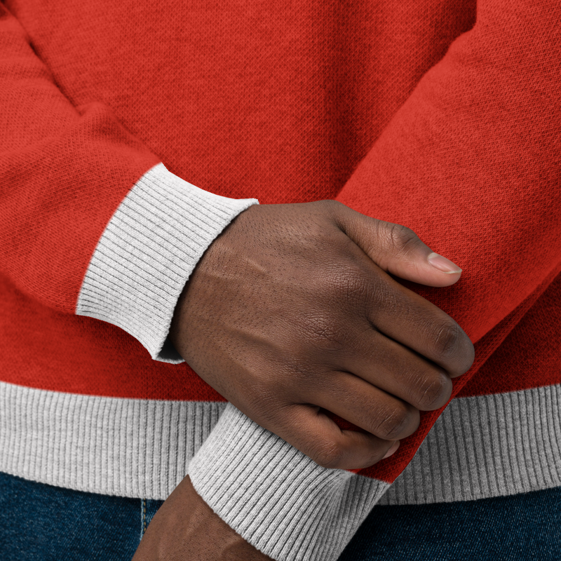 Close-up of hands wearing a red sweater with gray ribbed cuffs and hems.