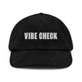 black corduroy cap with white text reading VIBE CHECK on the front