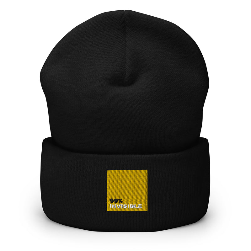 Black beanie hat featuring the text '99% INVISIBLE' in a yellow square on the rolled cuff.