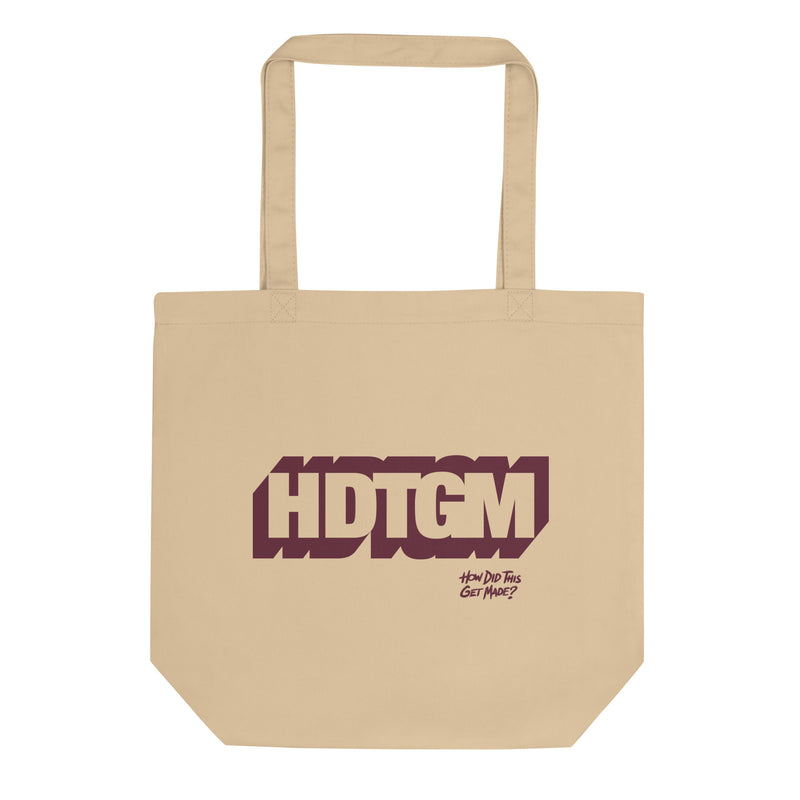 Cream colored canvas tote bag featuring maroon outlined graphic of 'HDTGM' initials and a smaller 'How Did This Get Made?' logo below.