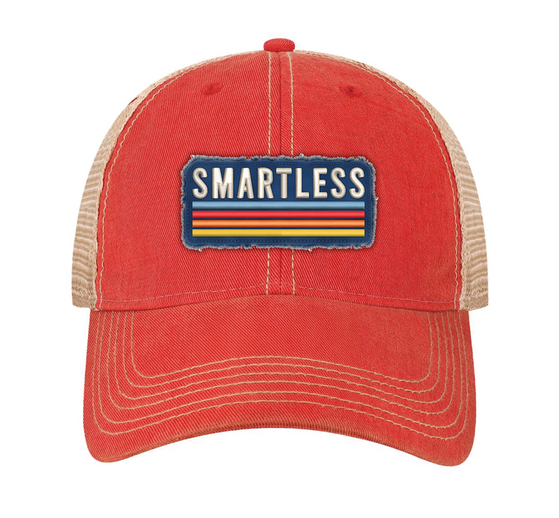 An orange baseball cap with a tan mesh back featuring a patch that says 'SMARTLESS' in white letters against a blue background with horizontal stripes.