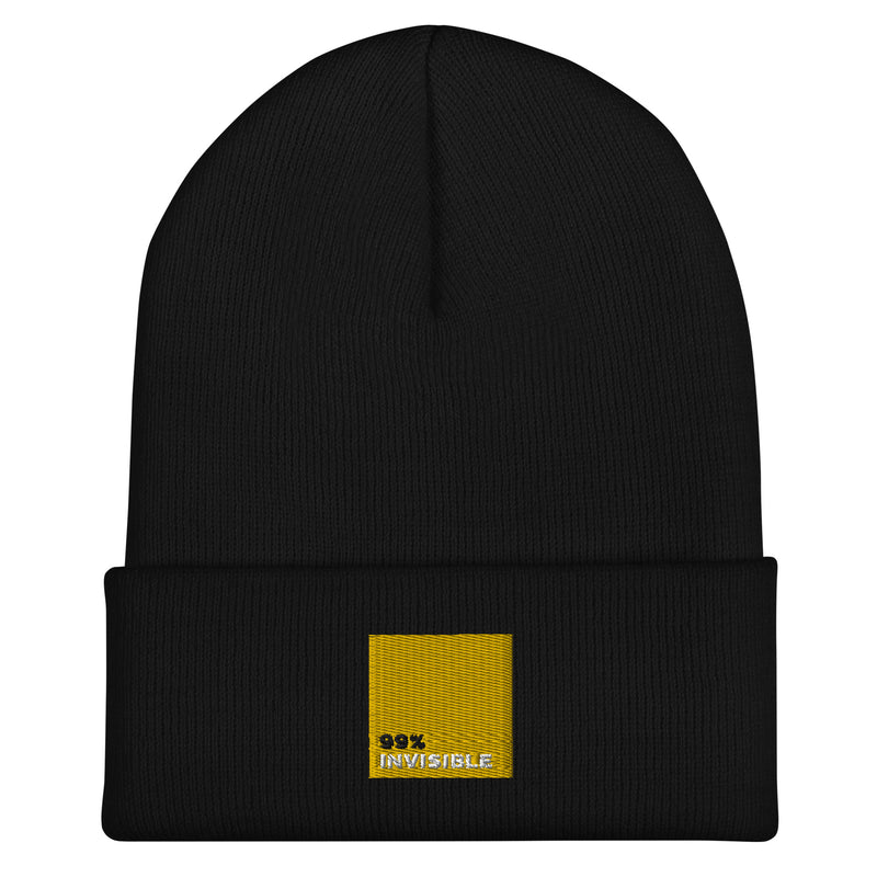 Black beanie hat featuring the text '99% INVISIBLE' in a yellow square on the rolled cuff.