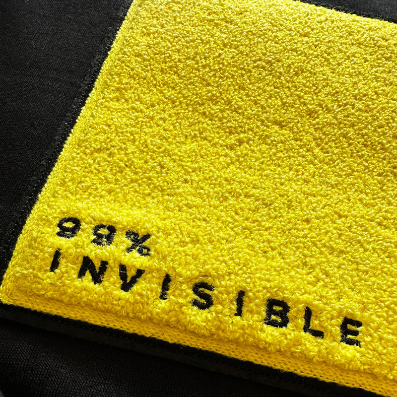 Yellow chanille patch with black text reading 98% INVISIBLE on a black background