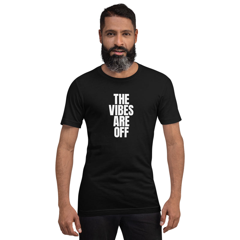 A man modeling the black 'THE VIBES ARE OFF' t-shirt, standing confidently against a plain white background. The t-shirt fits snugly, showcasing its classic cut and minimalist design.