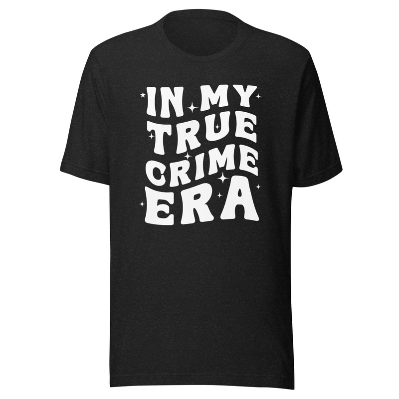 A black heather unisex t-shirt featuring bold white text on the front that reads 'IN MY TRUE CRIME ERA' in a playful, retro-style font, accented with small star-like sparkles. The shirt has a classic crew neck and a standard fit.