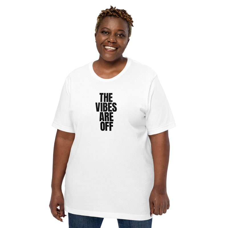 A woman wearing a white 'THE VIBES ARE OFF' t-shirt, standing against a plain white background. The shirt has a relaxed fit and features the bold text design in black.