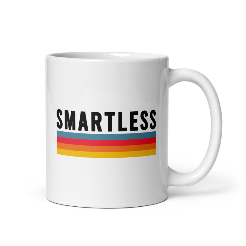 A white coffee mug featuring the word 'SMARTLESS' in bold black text above a colorful stripe design of blue, red, orange and yellow.