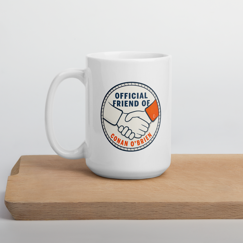 White mug with a circular logo featuring a handshake and the text Official Friend of Conan O'Brien