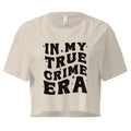 A bone-color cropped t-shirt with bold black text on the front that reads 'IN MY TRUE CRIME ERA' in a playful, retro-style font, accented with small star-like sparkles. The shirt has a relaxed fit, short sleeves, and a slightly boxy cut.