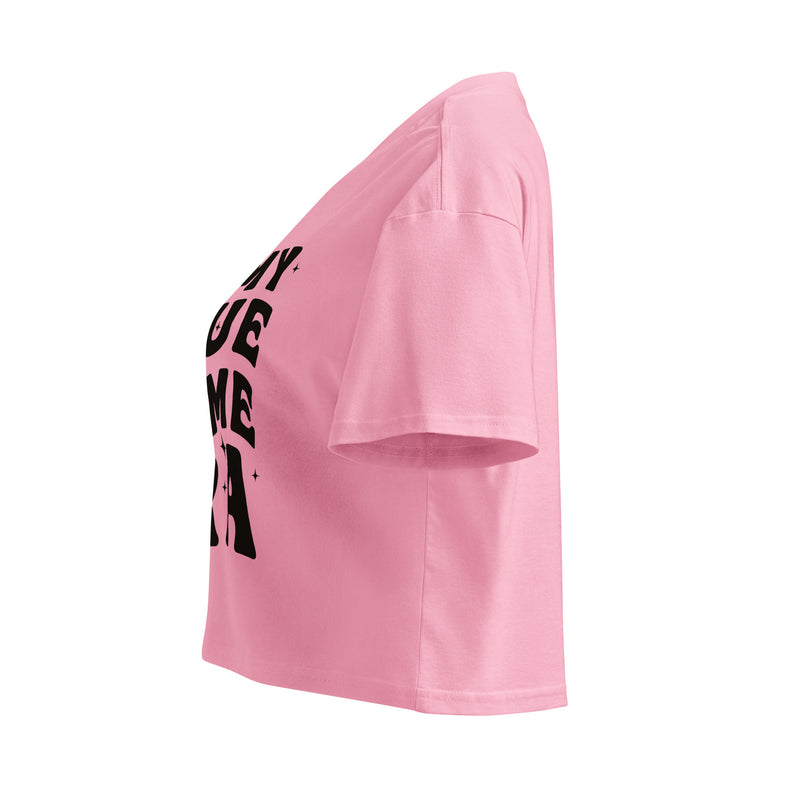 A side view of the pink cropped t-shirt, showing the short sleeves and slightly loose fit. The black text design is partially visible from this angle.