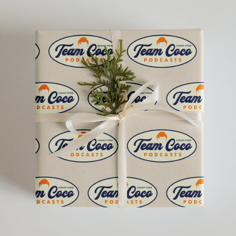 Gift wrapped box with Team Coco Podcasts logo and a sprig of greenery on top